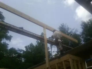 Carpenter setting a ridge beam over a new addition frame — Ice Dam Removal by Roofing Brothers in Cape Coral