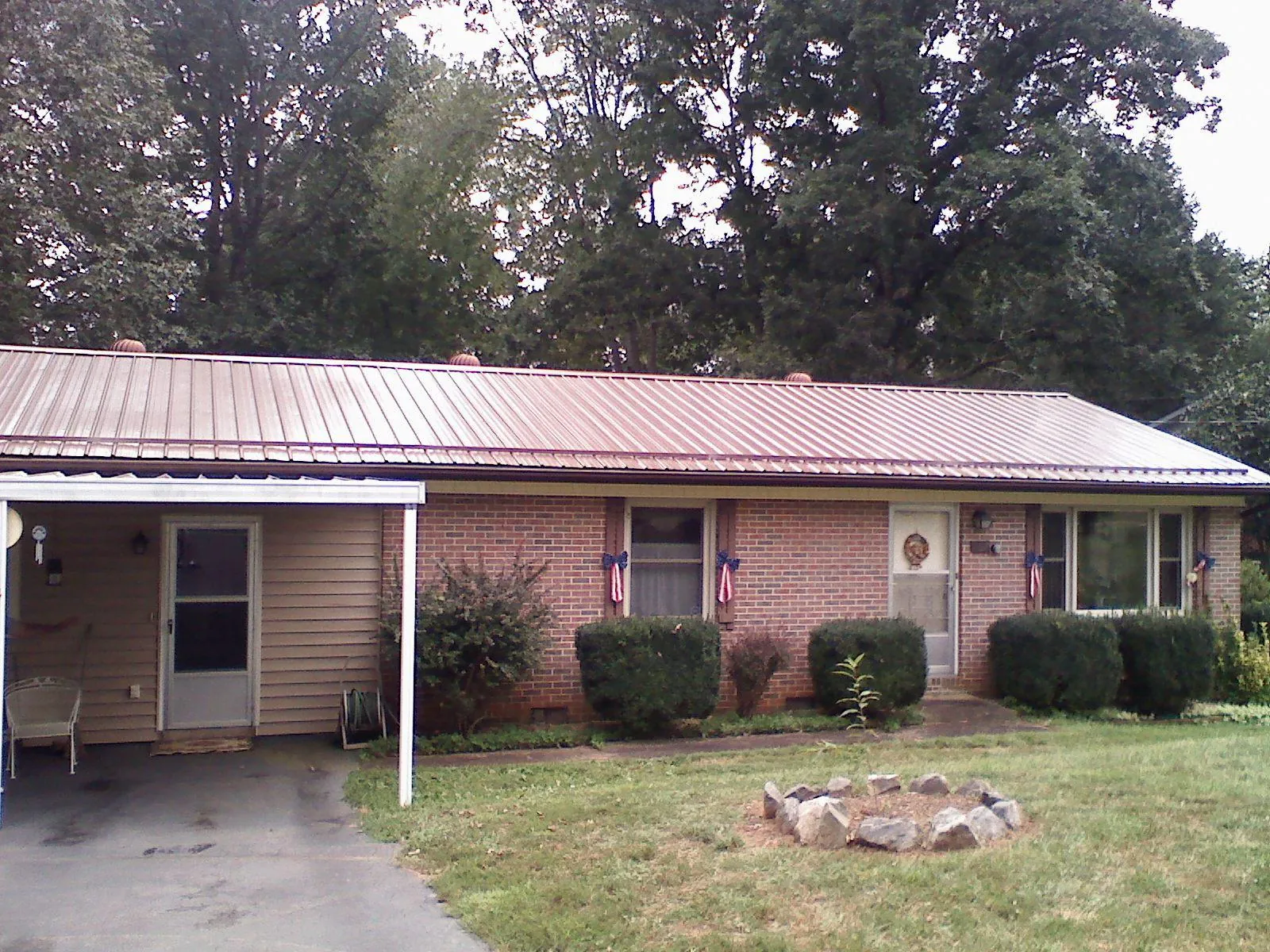 Bronze metal roof and carport on a brick ranch home — Roof Repair work by our crew in Cape Coral